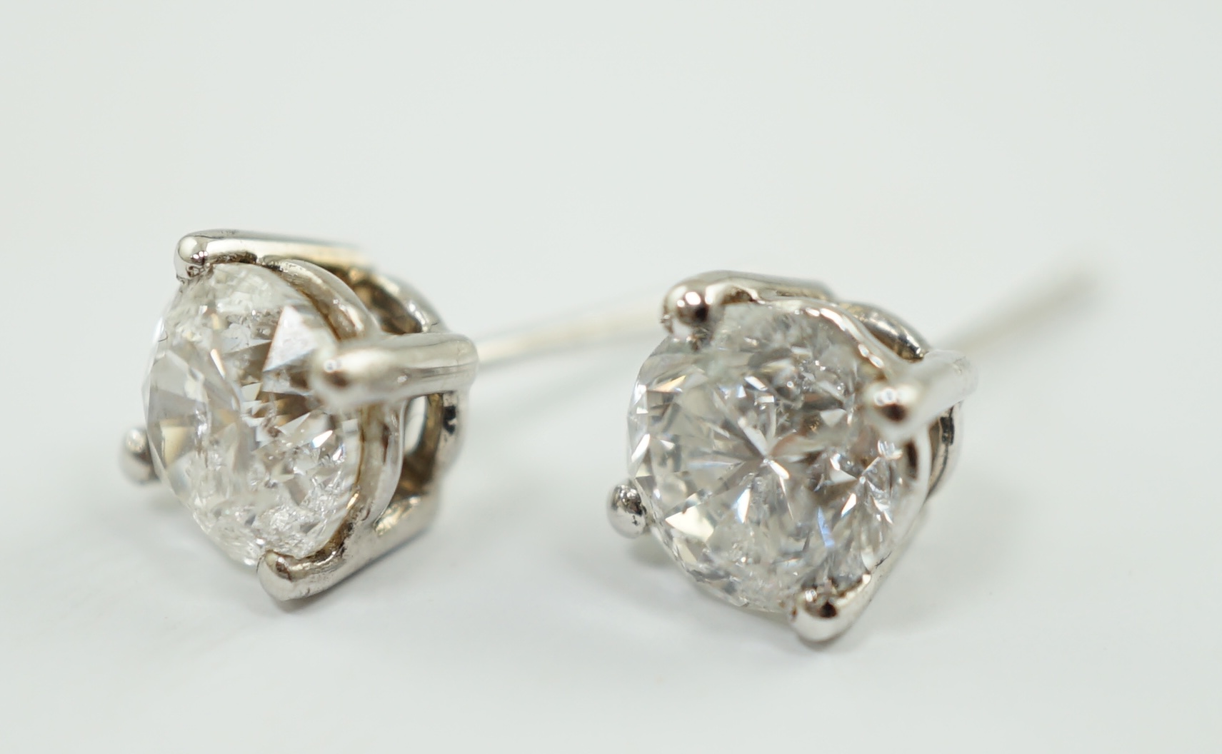 A modern pair of 18k white gold and round brilliant cut solitaire diamond set ear studs